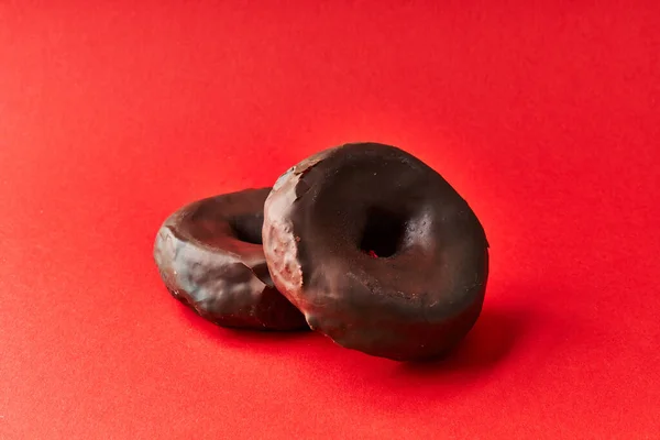 Dos Deliciosas Rosquillas Chocolate Sobre Fondo Rojo — Foto de Stock