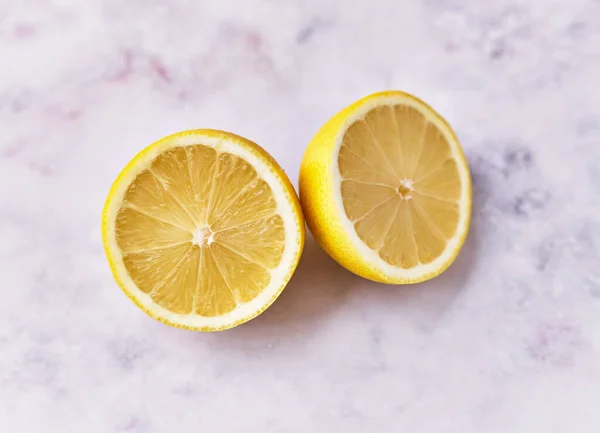 两个柠檬在大理石表面结出一半果 — 图库照片