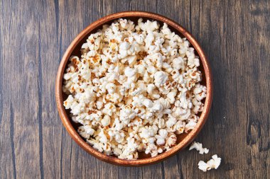  Tahta bir yüzeyde bir kase tuzlu patlamış mısır.