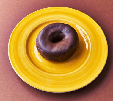  Kahverengi arka planda bir tabak çikolatalı çörek.