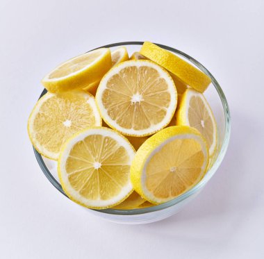  Beyaz arka planda izole edilmiş bir kase limon dilimi.