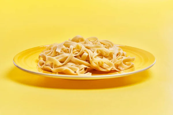 Plaat Van Italiaanse Tagliatelle Pasta Gele Achtergrond — Stockfoto