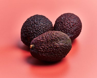  Three avocados fruit over red background