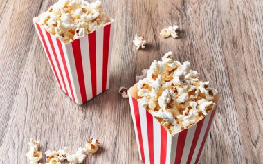  Tahta bir yüzeyde iki paket tuzlu patlamış mısır.