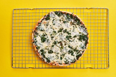  Single spinach italian pizza on oven steel tray on yellow background
