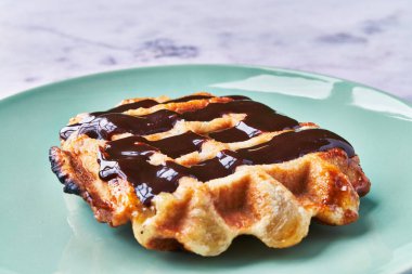  Mermer yüzeyinde çikolata olan lezzetli bir waffle tabağı.