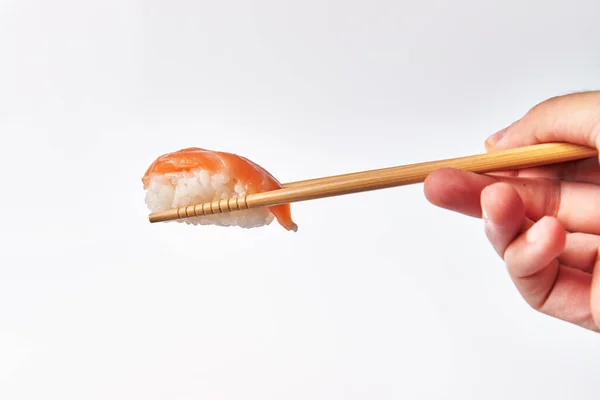 Pałeczki Trzymające Pojedyncze Sushi Łososiowe Nigiri Izolowane Białym Tle — Zdjęcie stockowe