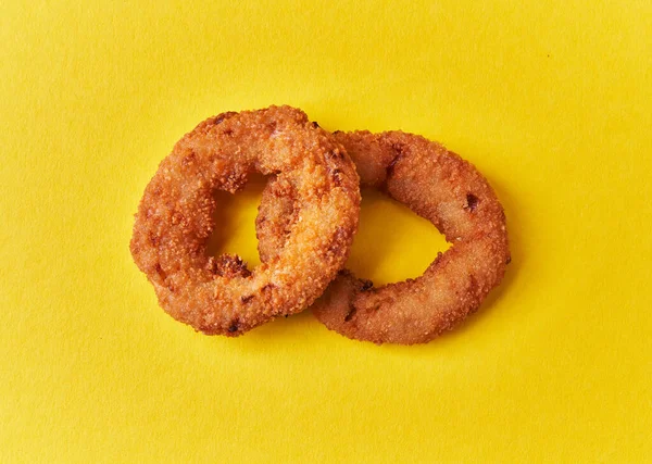 Two Breaded Onion Rings Yellow Background — Stock Fotó