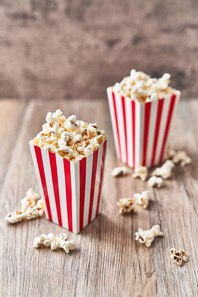  Tahta bir yüzeyde iki paket tuzlu patlamış mısır.