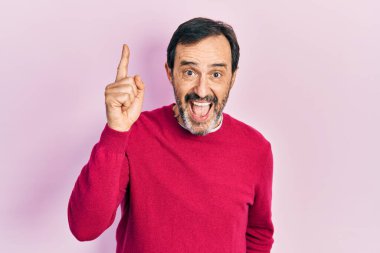 Gündelik kıyafetler giyen orta yaşlı İspanyol bir adam başarılı bir fikri işaret ediyor. Heyecanlı ve mutlu. Bir numara.. 