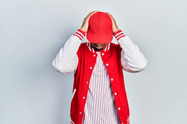 Beyzbol üniforması giyen genç Afro-Amerikan adam acı ve migren yüzünden çaresiz ve stresli. Eller başının üstünde.. 