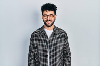 Young arab man with beard wearing glasses with a happy and cool smile on face. lucky person. 