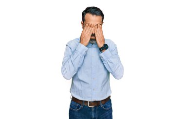 Orta yaşlı, sakallı, iş gömleği giyen, yorgunluk ve baş ağrısı için gözlerini ovuşturan, uykulu ve yorgun ifadeli bir adam. görme sorunu 