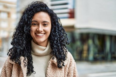 Sokakta kendinden emin gülümseyen genç İspanyol kadın.