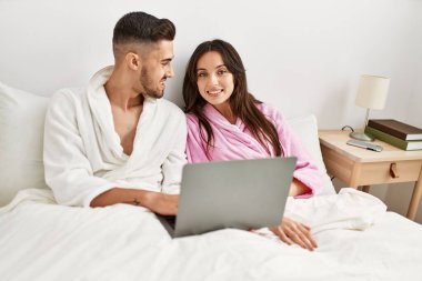 Genç İspanyol çift evde dizüstü bilgisayar kullanıyor..