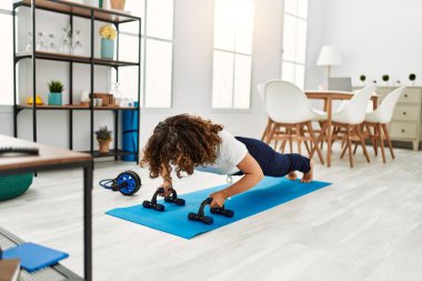 Olgun İspanyol kadın evdeki oturma odasında egzersiz yapıyor.