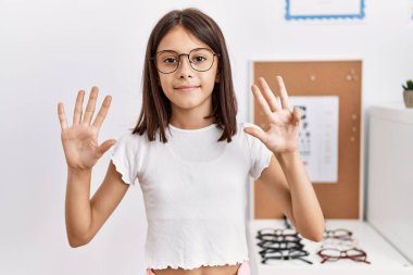 Young hispanic girl wearing glasses showing and pointing up with fingers number nine while smiling confident and happy. 