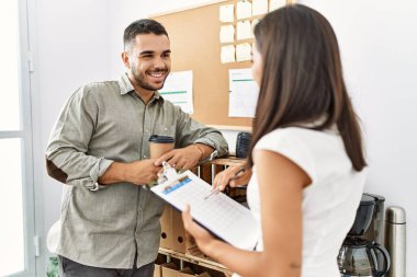 İki Latin iş adamı panoya yazı yazıp ofiste kahve içiyorlar..