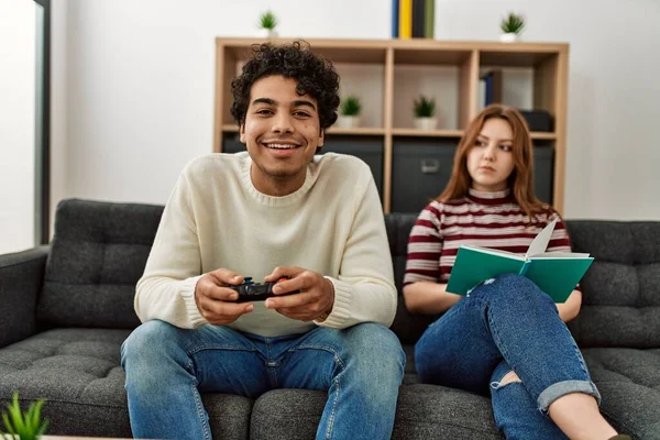 Man Speelt Video Game Terwijl Ongelukkige Vriendin Boek Lezen Thuis — Stockfoto