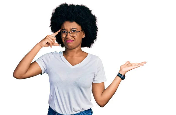 カジュアルな白いTシャツを着た若いアフリカ系アメリカ人女性は コピースペースと額に指を指すことを示す開いてヤシの木に混乱し 悩まされていました 考えてみてください — ストック写真