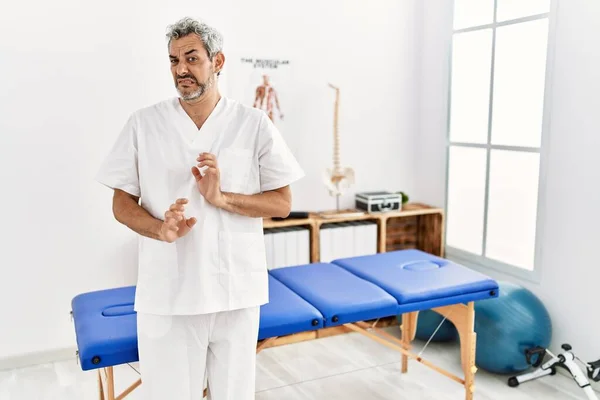 Middle Age Hispanic Therapist Man Working Pain Recovery Clinic Disgusted — Stockfoto