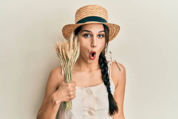 Young Hispanic Woman Wearing Summer Hat Holding Spike Wheat Scared — Foto Stock