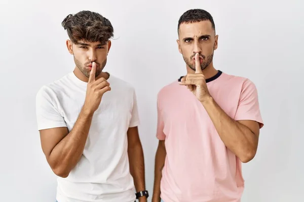 Young Gay Couple Standing Isolated Background Asking Quiet Finger Lips — Stock Fotó