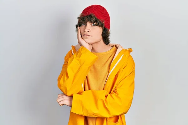 Handsome Young Man Wearing Yellow Raincoat Thinking Looking Tired Bored — Stockfoto