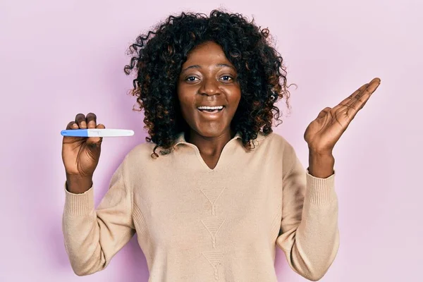 Young African American Woman Holding Pregnancy Test Result Celebrating Victory — Stok fotoğraf