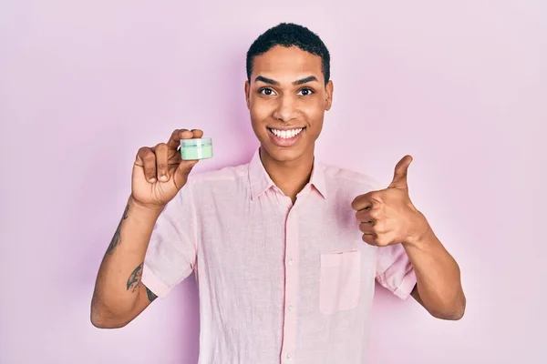 Young African American Guy Holding Face Moisturizer Cream Smiling Happy — Stock fotografie