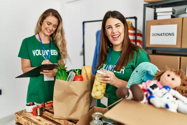 Twee Jonge Vrijwilligers Vrouw Lachend Gelukkig Werkend Bij Liefdadigheidscentrum — Stockfoto