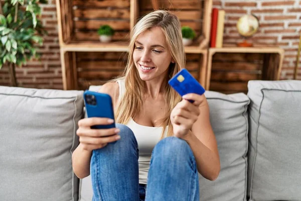 Junge Blonde Frau Sitzt Mit Smartphone Und Kreditkarte Hause Auf — Stockfoto