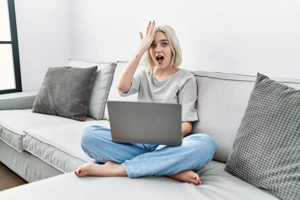 Young Caucasian Woman Using Laptop Home Sitting Sofa Surprised Hand — 스톡 사진