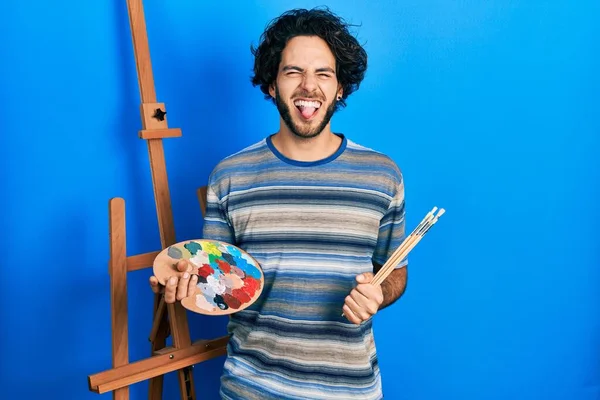 Handsome Hispanic Man Standing Drawing Palette Painter Easel Stand Sticking — Stock fotografie