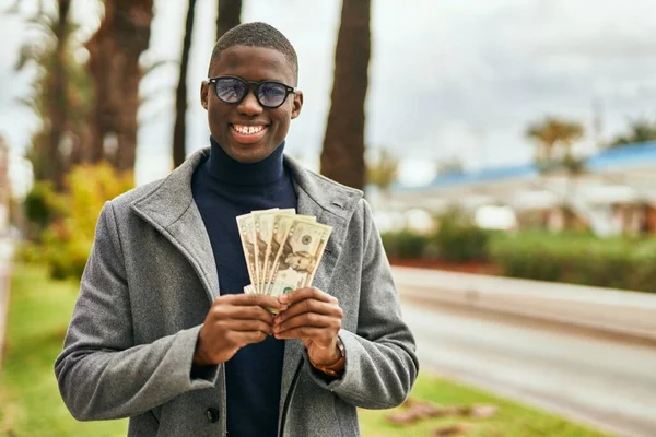 Νεαρός Αφροαμερικάνος Χαμογελά Χαρούμενος Κρατώντας Αμερικανικά Δολάρια Στην Πόλη — Φωτογραφία Αρχείου