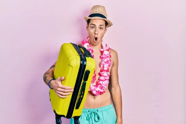 Young Hispanic Man Wearing Summer Hat Holding Cabin Bag Scared — Foto de Stock