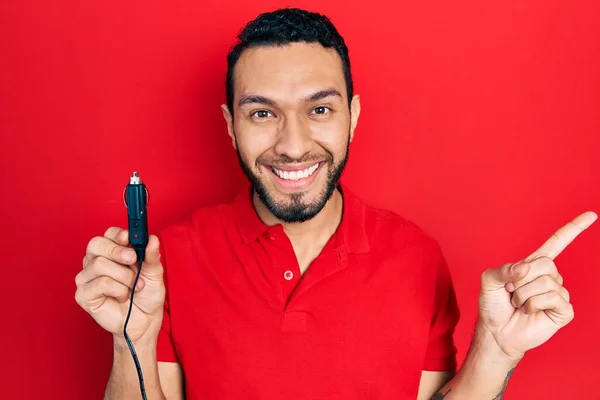 Hispanic Man Beard Holding Car Charger Smiling Happy Pointing Hand — 스톡 사진