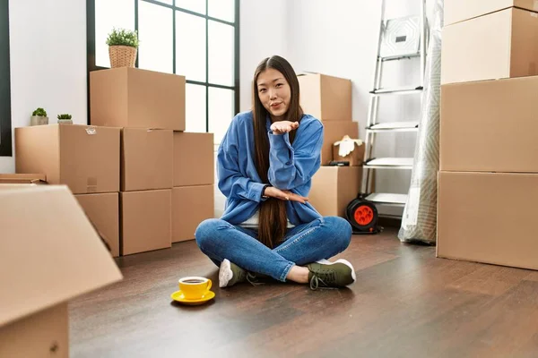 Young Chinese Girl Sitting Floor New Home Looking Camera Blowing — Stok fotoğraf