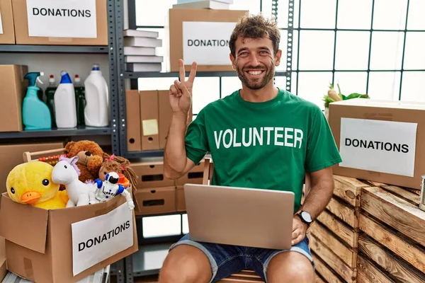 Young Handsome Man Wearing Volunteer Shirt Using Laptop Smiling Looking — Foto de Stock