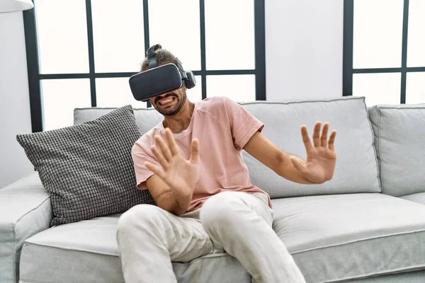 Handsome Hispanic Man Afraid Wearing Virtual Reality Glasses Living Room — Stock Photo, Image