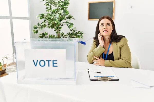 Jonge Brunette Vrouw Zit Aan Verkiezingstafel Met Stembiljet Aanraken Mond — Stockfoto