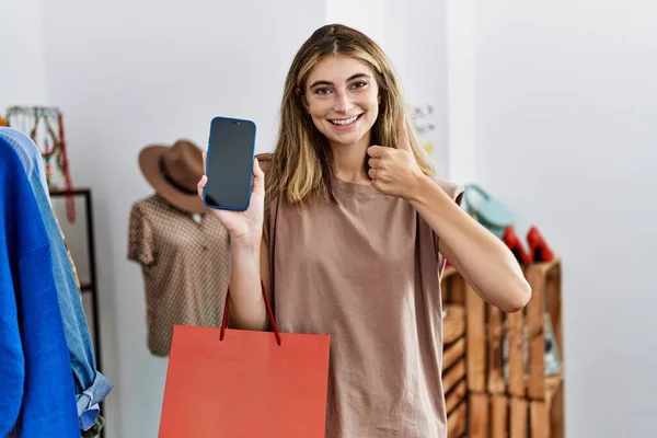 Young Blonde Woman Holding Shopping Bags Showing Smartphone Screen Smiling — Stockfoto