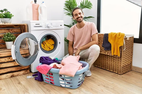 Jovem Hispânico Colocando Roupa Suja Máquina Lavar Roupa Olhando Para — Fotografia de Stock
