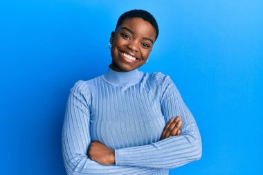 Young african american woman wearing casual clothes happy face smiling with crossed arms looking at the camera. positive person. 
