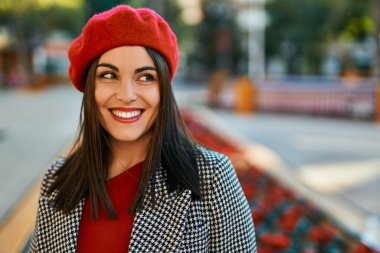 Genç İspanyol kadın gülümseyerek şehirde mutlu mesut dikiliyor..