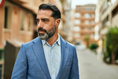 Şehirde duran rahat yüzlü orta yaşlı iş adamı..