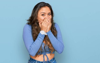 Günlük kıyafetler giyen genç İspanyol kız gülüyor ve utanıyor kıkırdıyor ağızlarını ellerle kapatıyor, dedikodu yapıyor ve skandal konsepti yapıyor. 