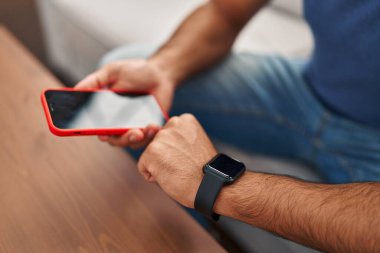 Genç İspanyol adam akıllı telefon ve akıllı telefon kullanıyor.