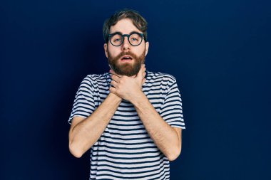 Sakallı, çizgili tişörtlü ve gözlüklü beyaz bir adam bağırıyor ve boğuluyor çünkü acı verici bir boğulma. Sağlık problemi. Boğulma ve intihar konsepti. 