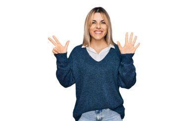Gündelik giysiler giyen genç beyaz kadın sekiz numarayı gösterip işaret ederken kendinden emin ve mutlu bir şekilde gülümsüyor.. 